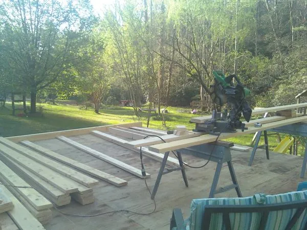 Miter saw and framing lumber on a deck under construction in Bradford